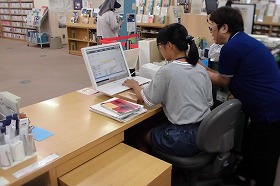 カウンターで返却作業をする小学生