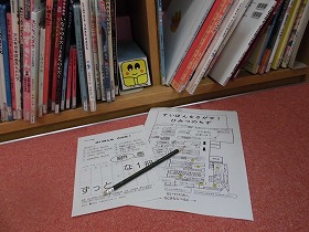 本棚に隠れているすいぽんと問題用紙、図書館の地図、鉛筆の写真