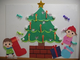 モミの木が飾られ、その下にクリスマスプレゼントとくつしたが置かれ、子どもがサンタさんを待っている。
