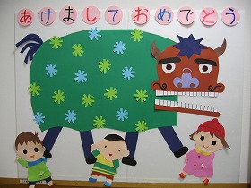 獅子舞と3人の子どもが遊んでいる壁面装飾。