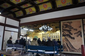 千里寺本堂で講師の話に聞き入る参加者。